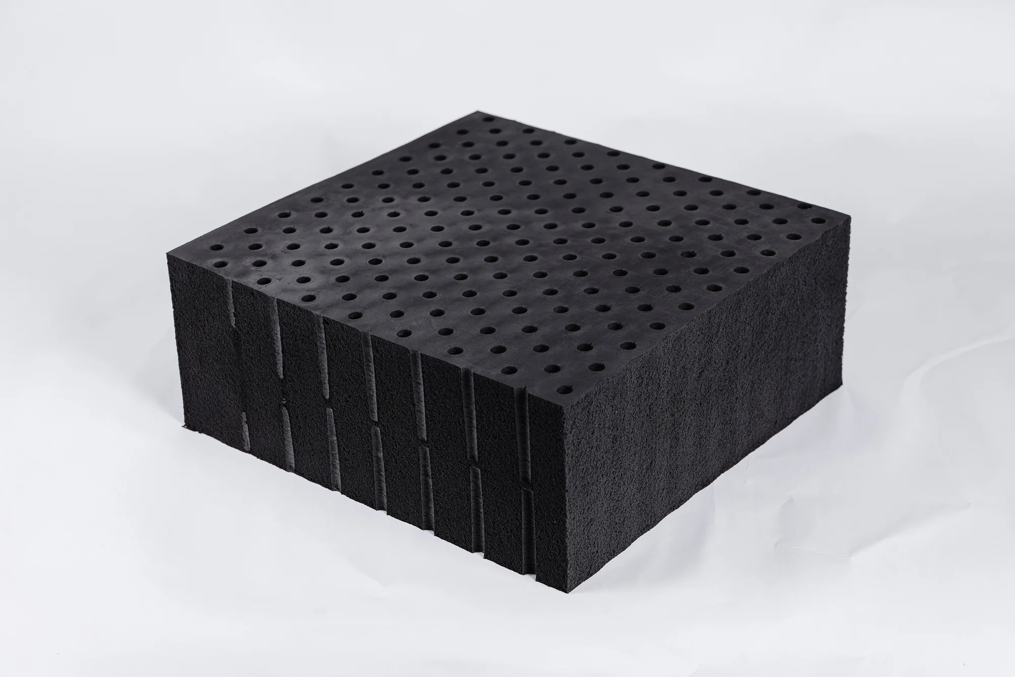 Graphite-infused latex block showing its dark charcoal color and texture