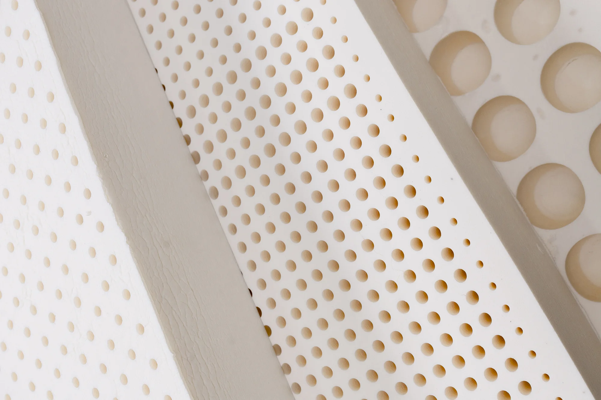 Close-up of a natural latex layer with visible perforation holes